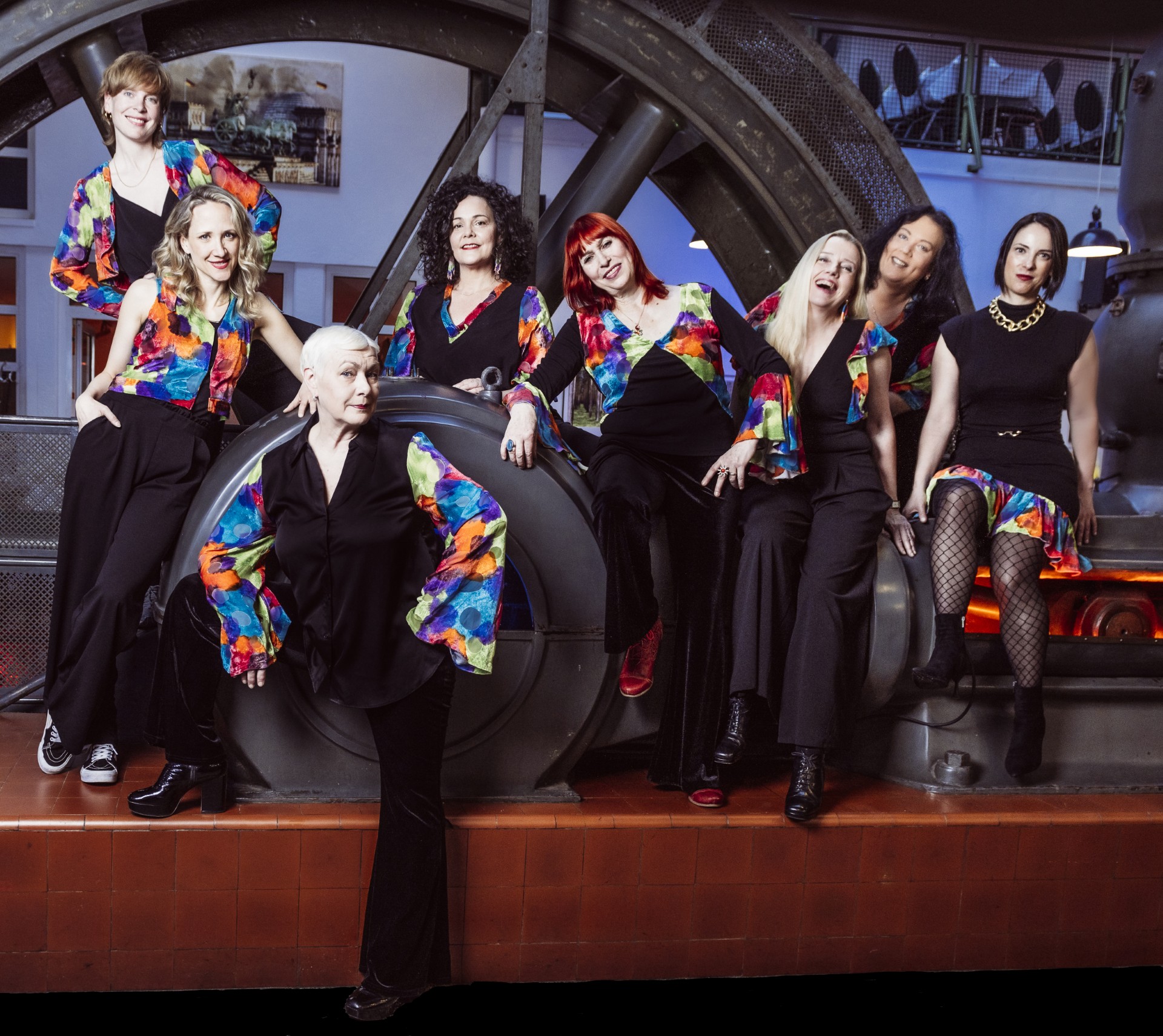 Acht Frauen in gleichen Outfits posieren für ein Bild.